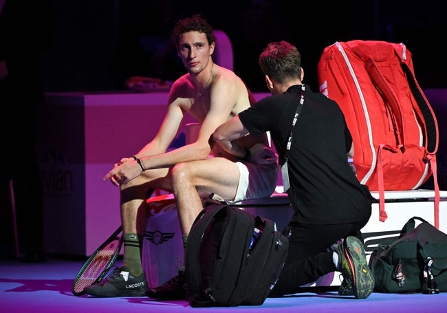Un fiisioterapeuta masajea en la espalda a Ugo Humbert tras el tercer juego del primer set.